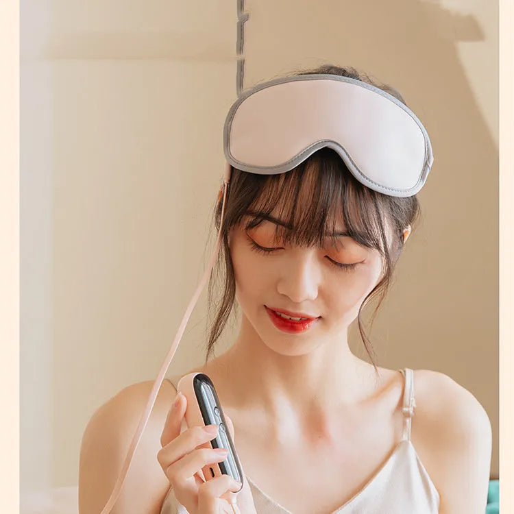 Green portable eye spa massage goggles with USB cable on a table.