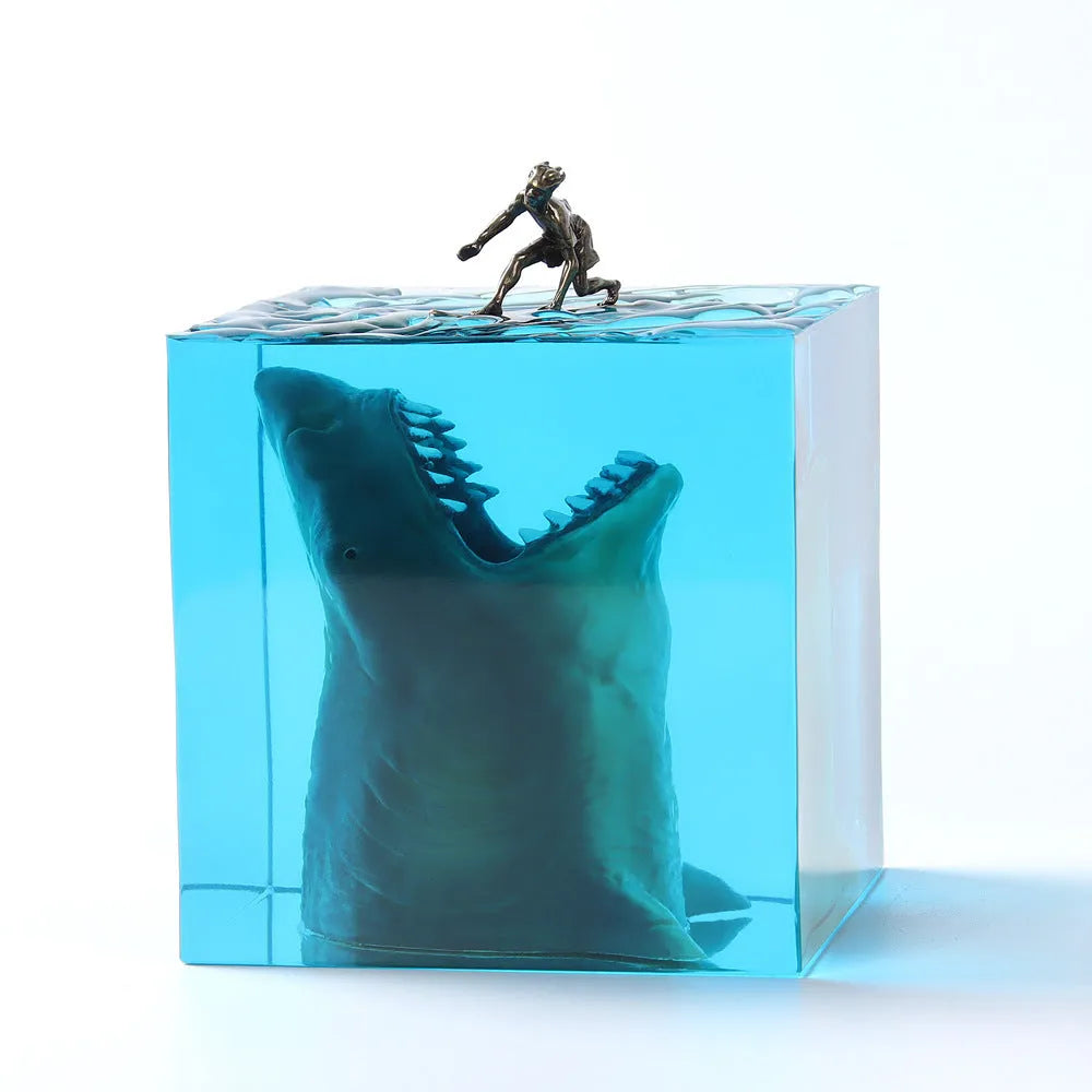 Clear epoxy resin ornament with a shark surfing scene inside, shown next to a 5cm and 8cm size option.