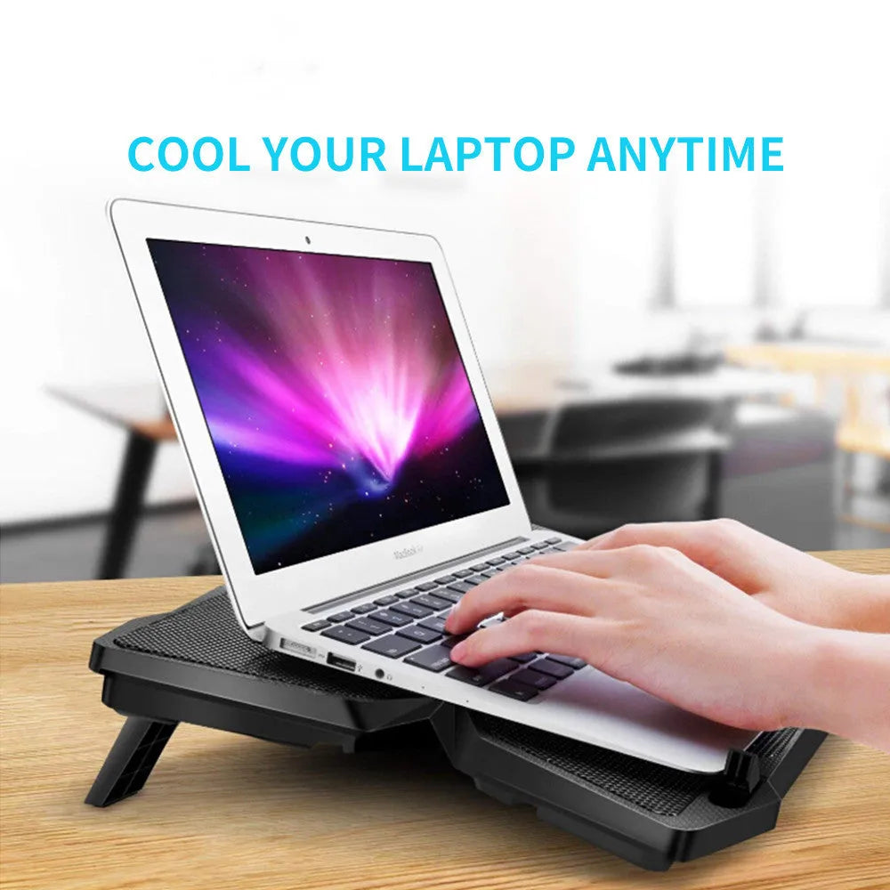 Blue PC cooling fan base with four LED-lit fans, speed switches, and USB ports on a desk.
