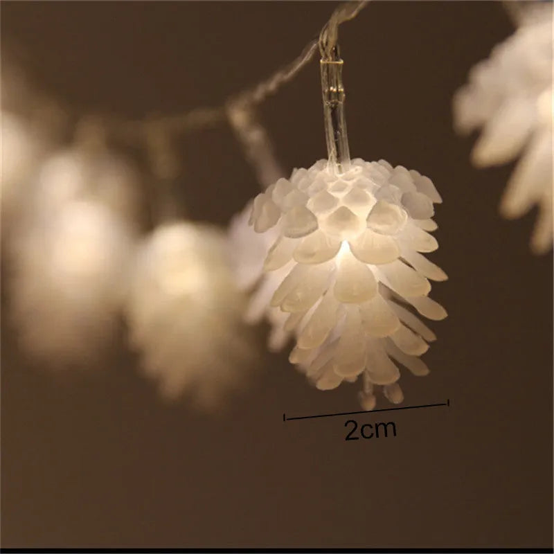 Battery-operated warm white LED string lights with pine cone shaped plastic shells.