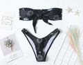 Black nylon one-piece swimsuit with bikini print pattern and backless tube top design