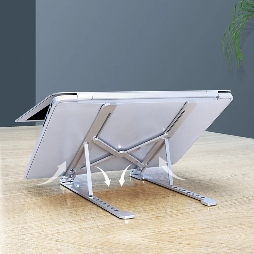 Aluminium laptop stand folded flat next to an open laptop showing adjustable height settings.
