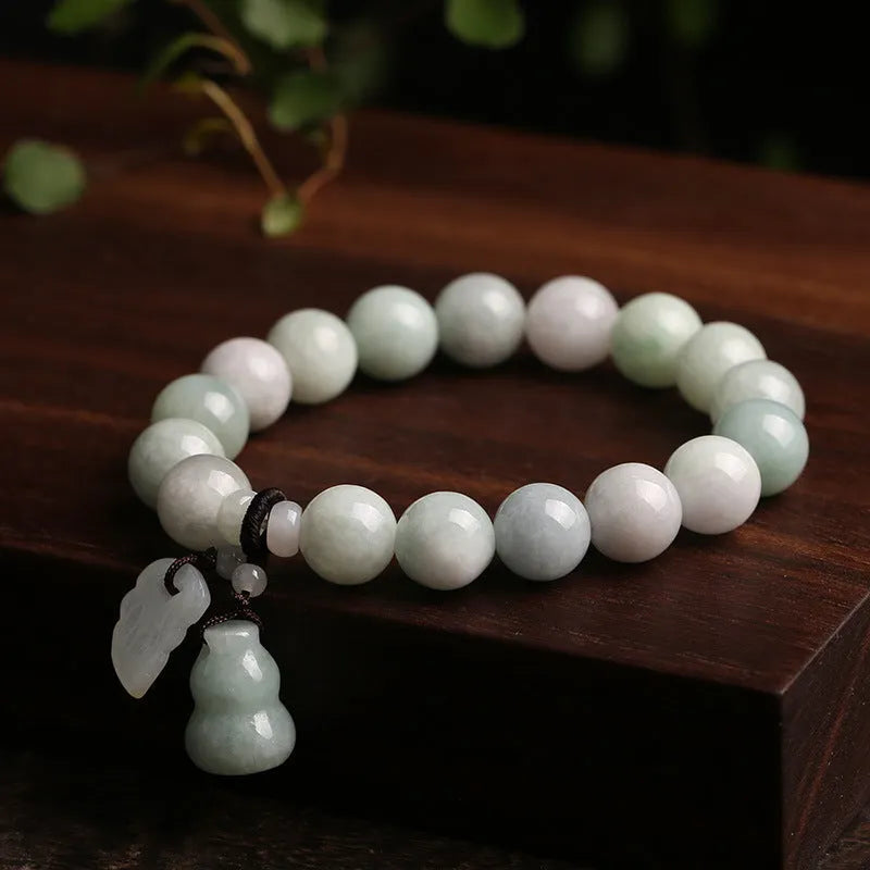 Natural green jade bracelet with a hanging Maitreya Buddha charm on a geometric band.