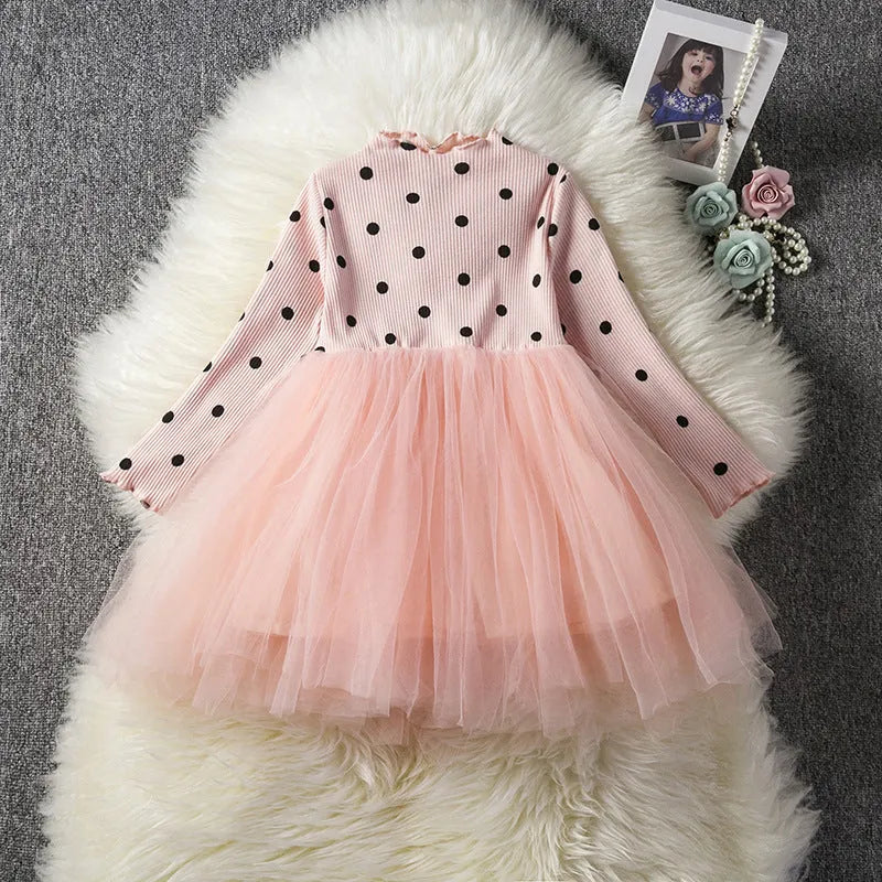 Baby girl wearing a long sleeve white tutu lace dress for a christening or birthday party.