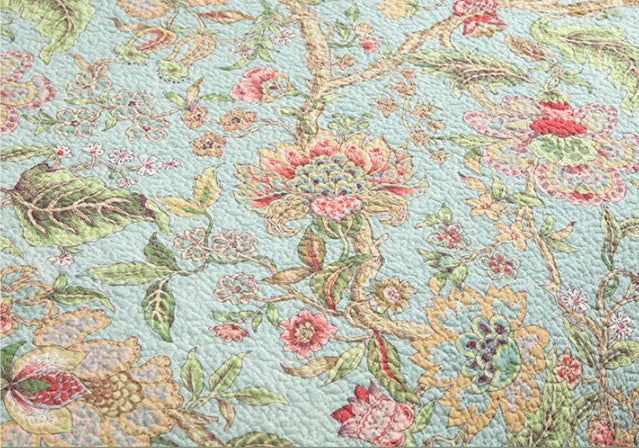 Blue American flower and bird pattern quilted cotton bedspread set on a bed