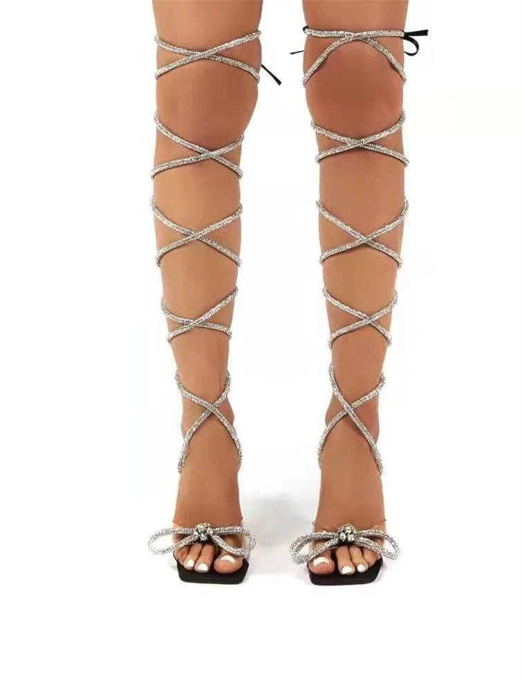 Plus size black strappy high-heeled sandals with rhinestone decoration on a square toe.