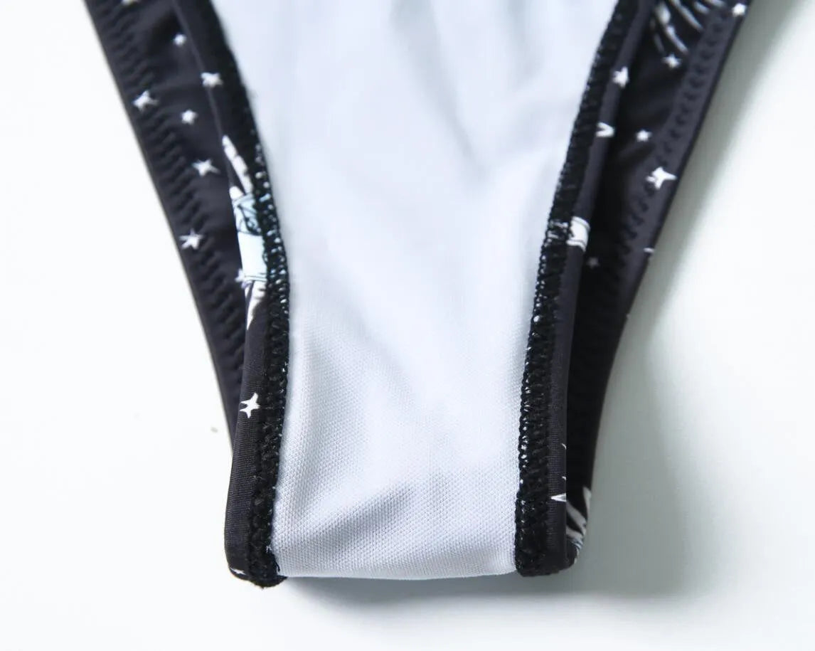 Black nylon one-piece swimsuit with bikini print pattern and backless tube top design