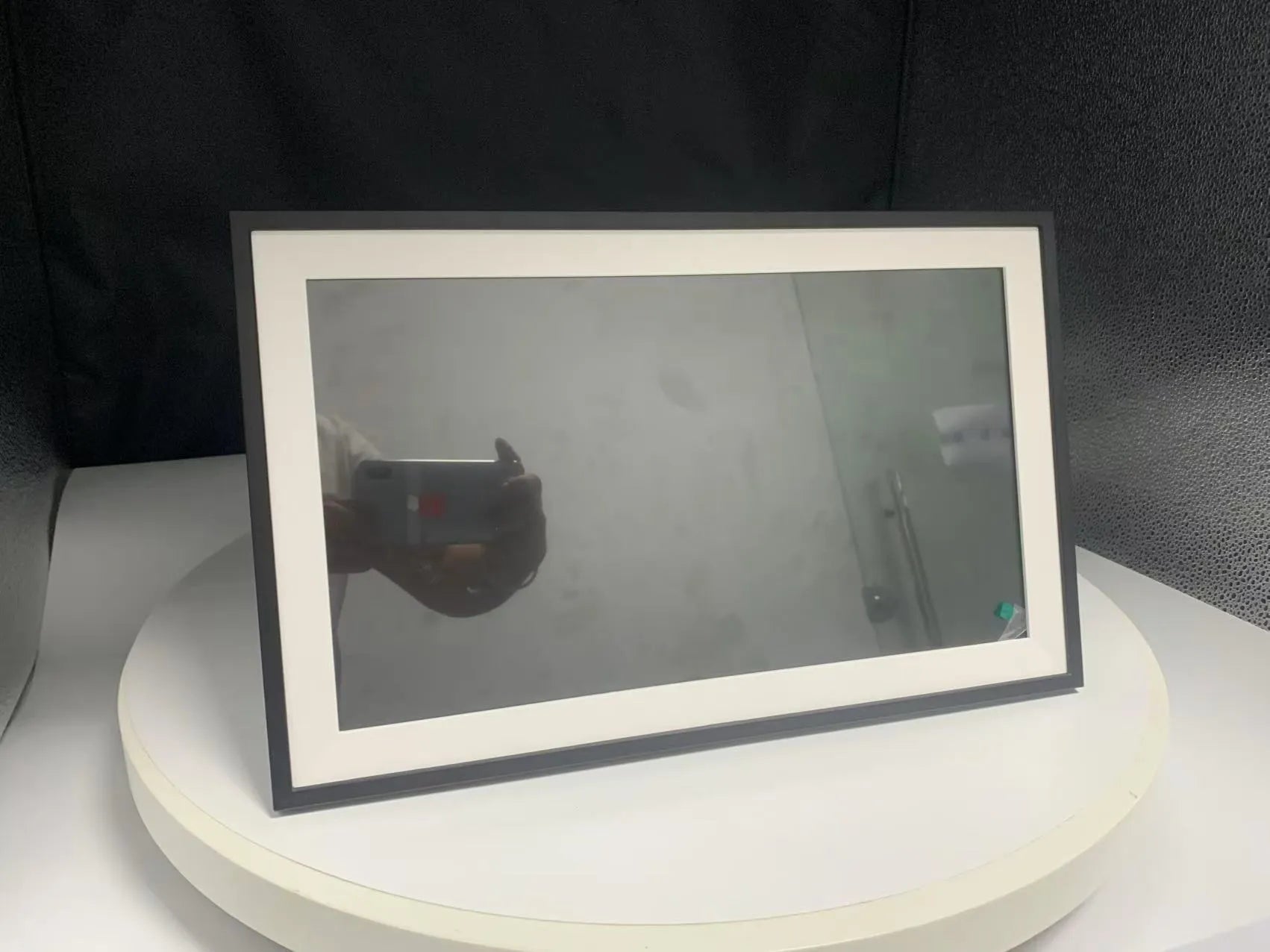 White smart digital photo frame with 15.6 inch screen on a table.