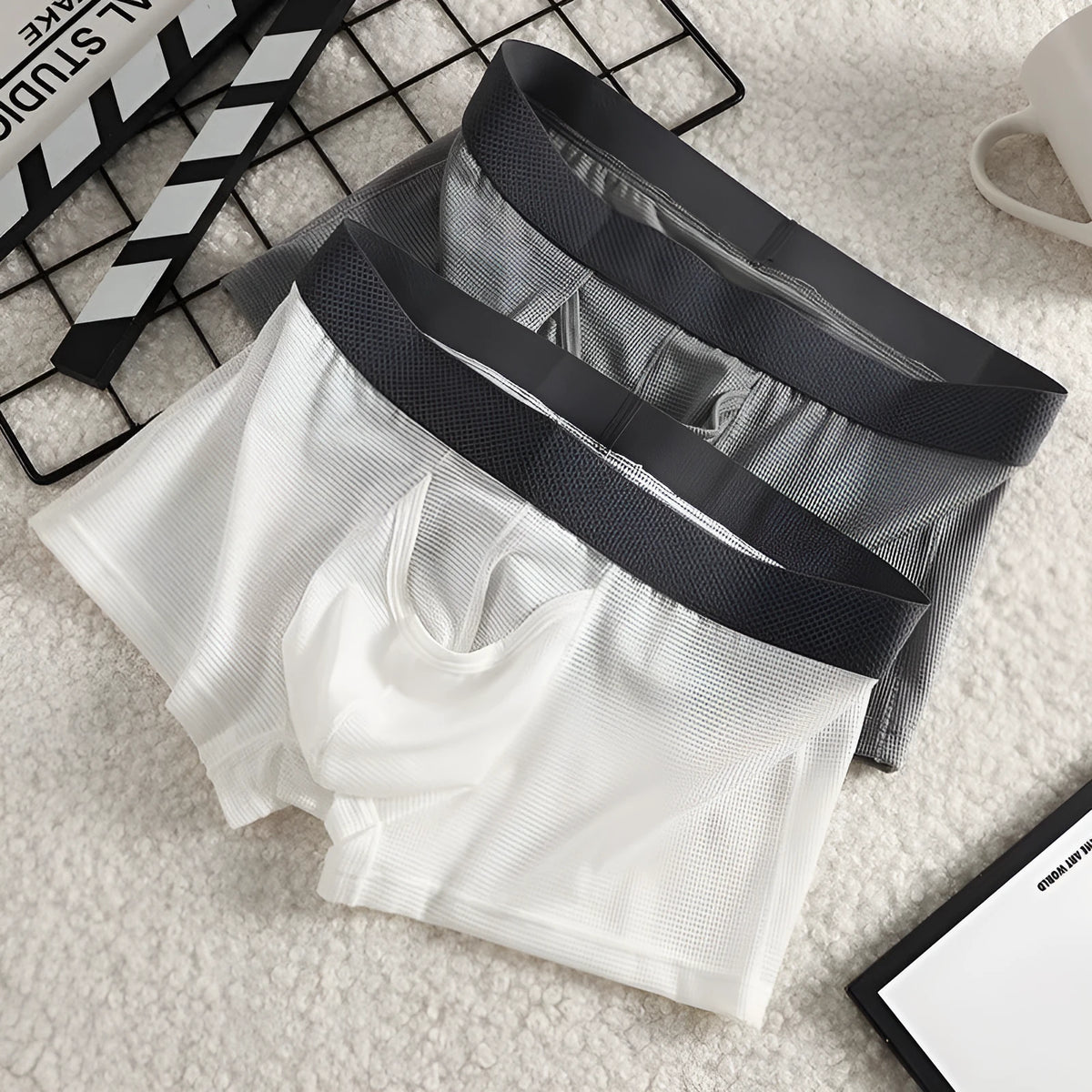 Men's solid colour ice silk mesh boxer underwear on a grey background, showing low waist design.