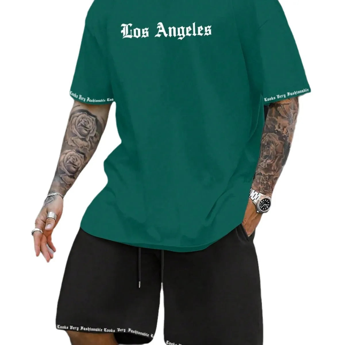 Man wearing a grey short-sleeve top and matching shorts from a sports co-ord set.