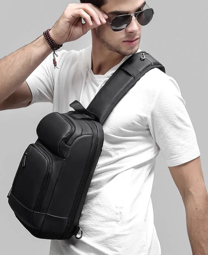 Black PVC outdoor shoulder bag with air cushion strap showing internal computer pocket and organisational compartments