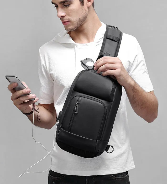 Black PVC outdoor shoulder bag with air cushion strap showing internal computer pocket and organisational compartments