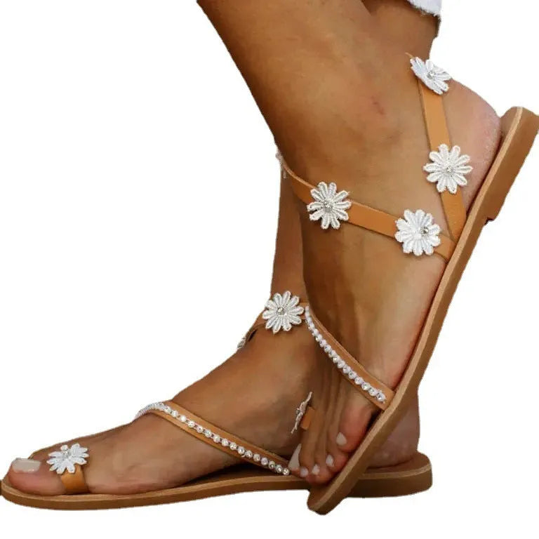 Brown Roman sandals with floral pattern, flat rubber sole, and herringbone toe design