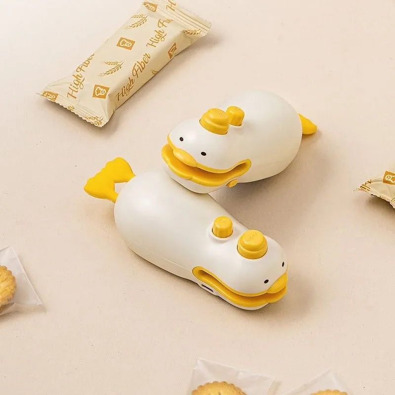 Yellow duck patterned rechargeable handheld vacuum food sealer with USB charging cable.