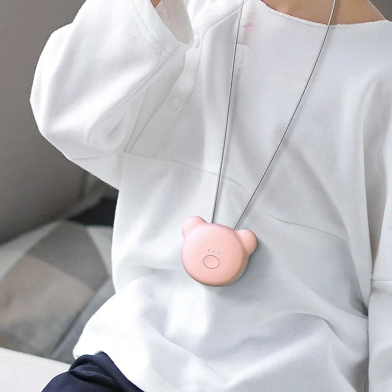 Pink and blue wearable USB air purifier necklace shown on a person, with dimensions 1.5 by 5.7 by 4.5 cm.