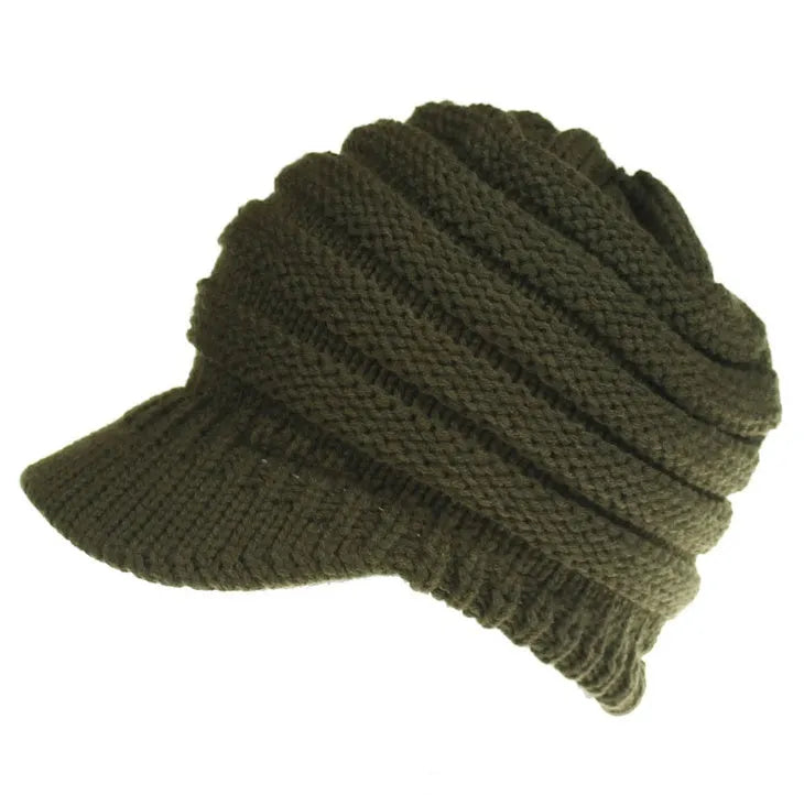 Woman wearing a soft knitted beanie with a ponytail pulled through the opening in the crown.