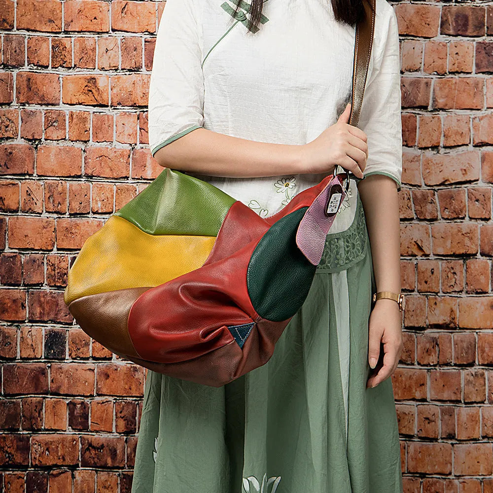 Brown cowhide leather crossbody travel bag open showing space for a laptop and personal items.