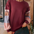 Women's beige and red plaid long-sleeved loose-fit polyester top on a hanger.