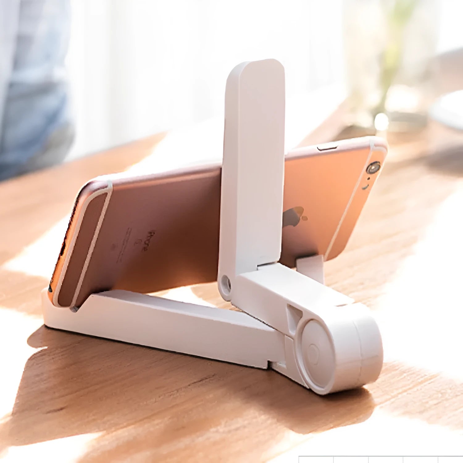 Black foldable tablet holder open in landscape mode holding a smartphone, showing its adjustable angle and non-slip base.