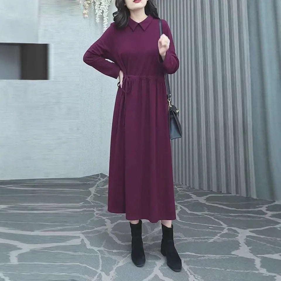 A purplish red plus size long sleeve dress with a long skirt, shown on a model.