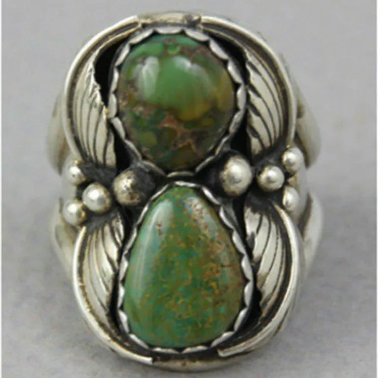 A geometric turquoise ring with a retro inlaid design on a woman's hand.