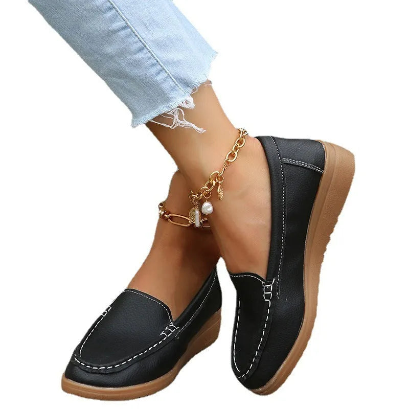 Women's flat loafers in PU leather showing round toe, car suture detail, and a flat rubber sole.