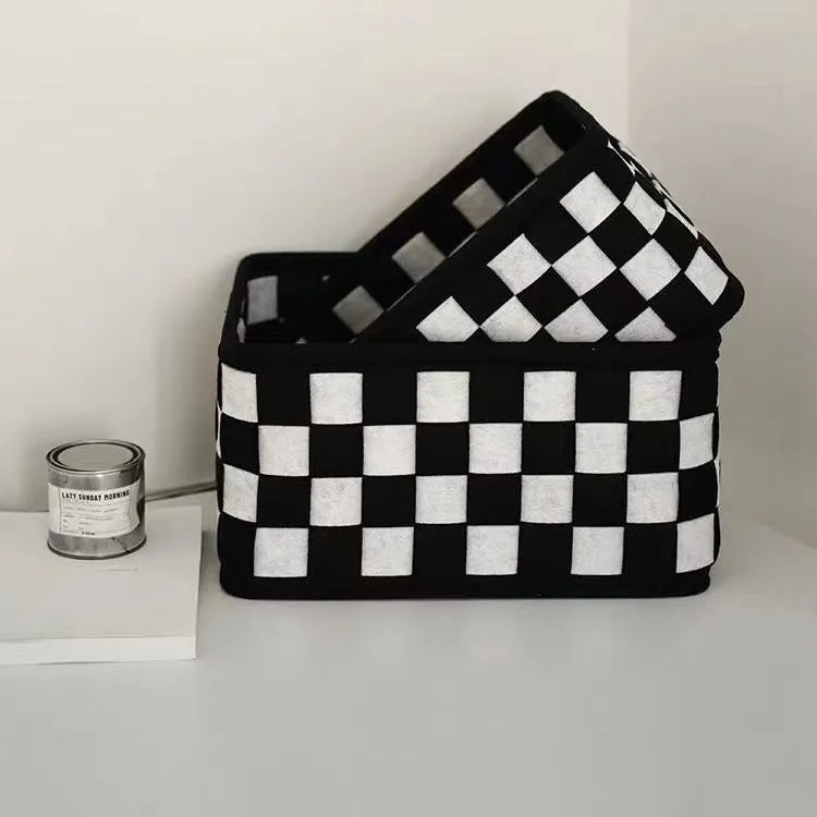 Grey and black checkerboard woven felt folding storage box with collapsible sides.