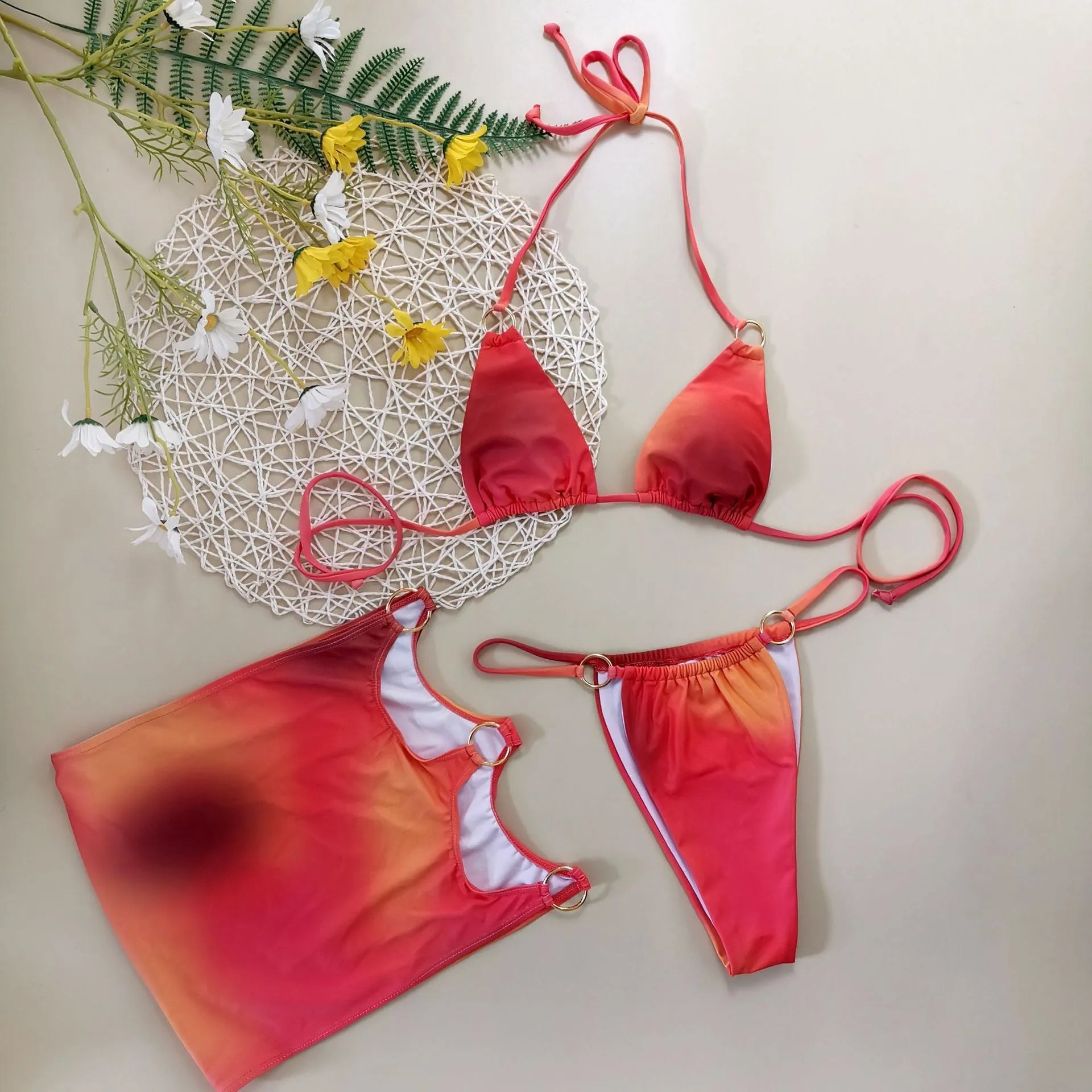 Solid colour three-piece halter bikini swimsuit set with matching skirt on swimwear hanger