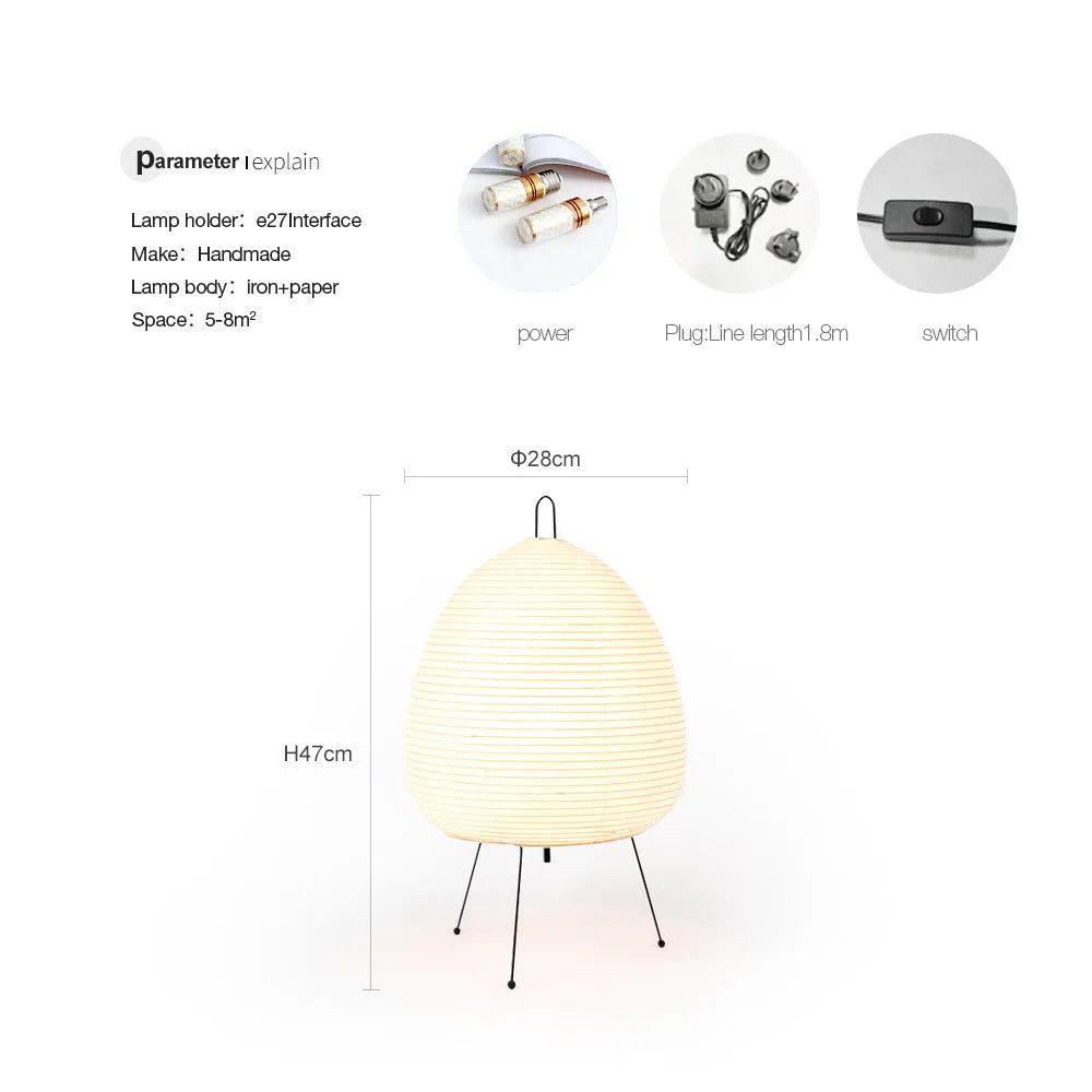 Japanese style table lamp with a white handmade paper lantern shade and aluminium base on a wooden table.