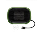 Green mini PTC ceramic heater with metal mesh front on a wooden desk