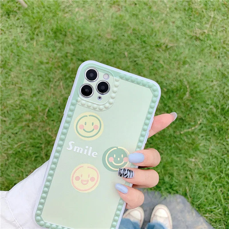 Green geometric pattern TPU iPhone case with polka dot frame and smiley faces, shown from the back.