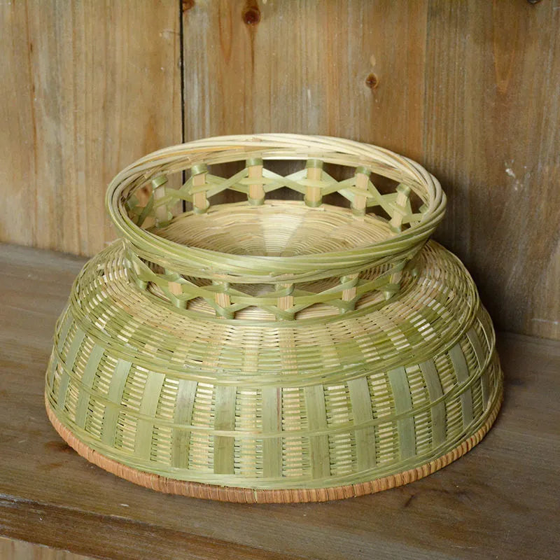 Handmade natural bamboo woven storage basket in three different sizes on a table.