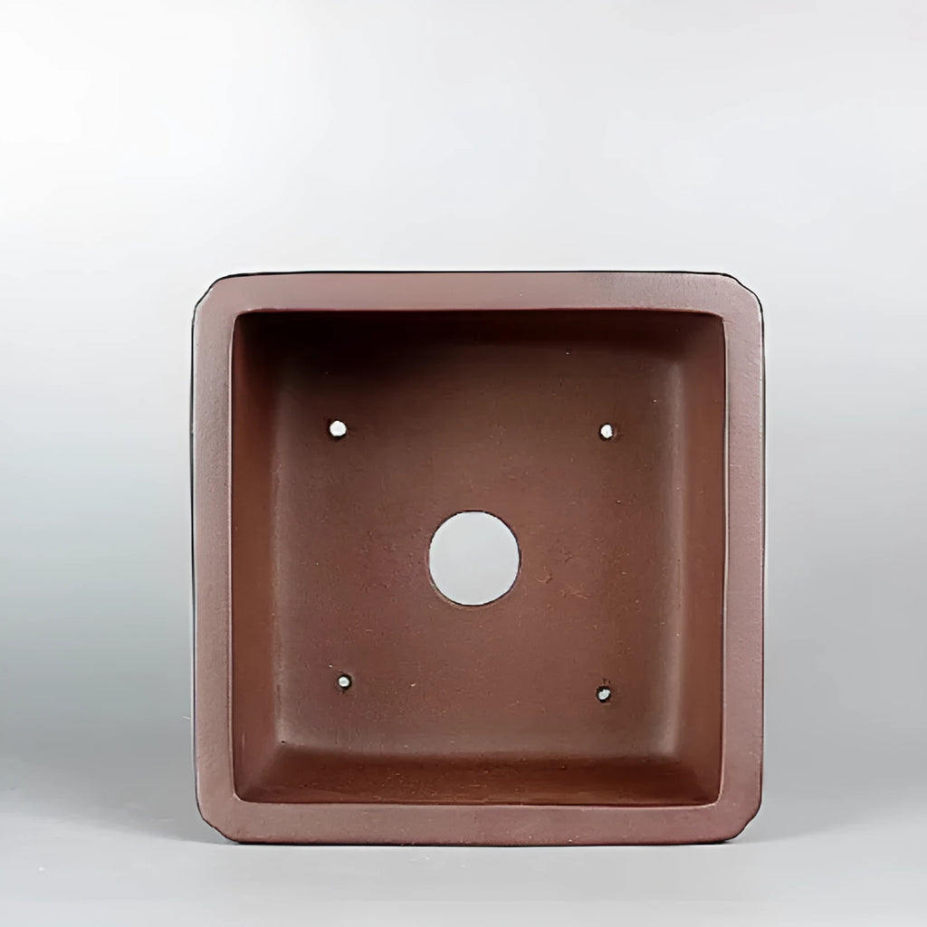 Brown handmade purple clay antique flower pot with single drainage hole.