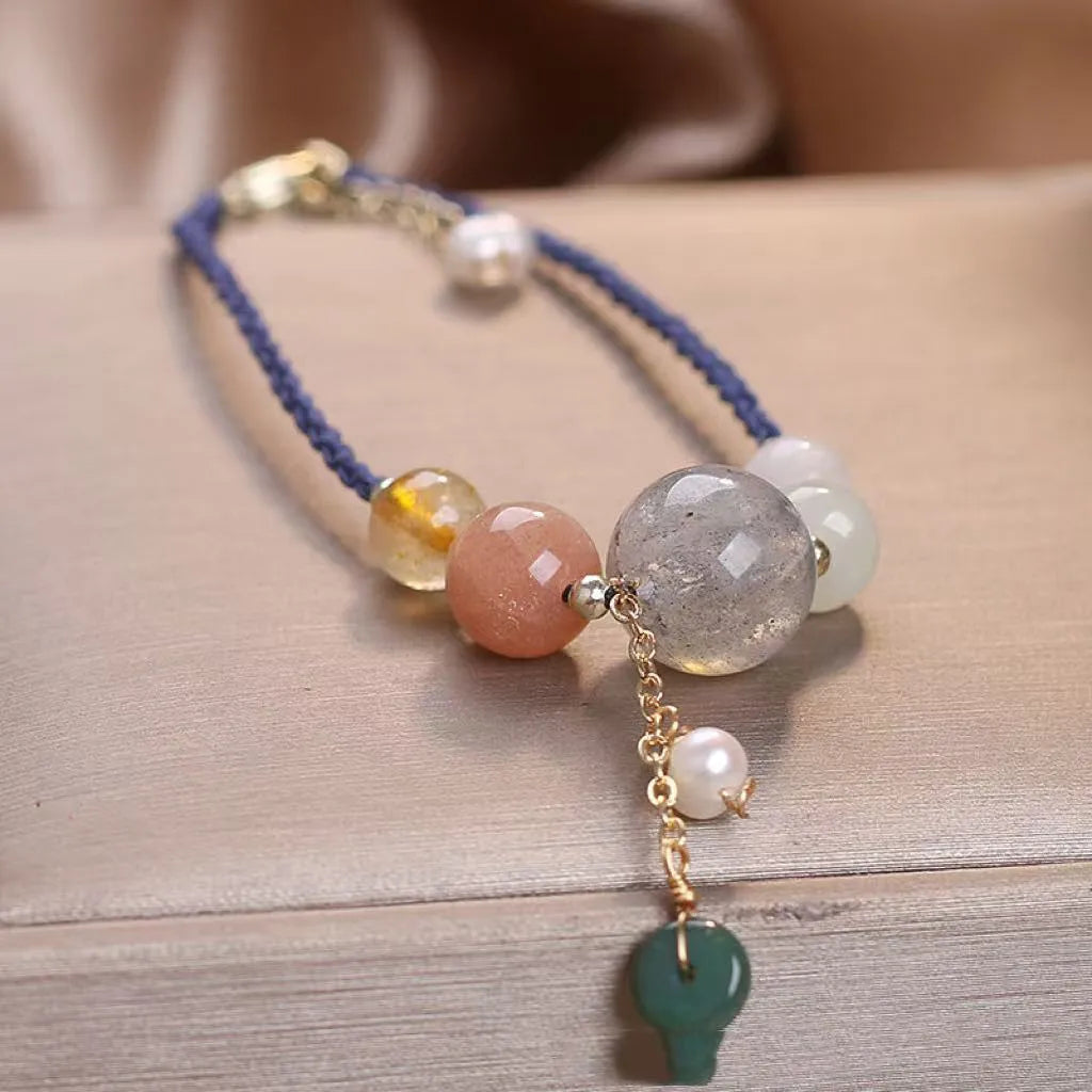 Close-up of a women's adjustable bracelet with crystal and sequin details on a hand-woven peace buckle clasp.