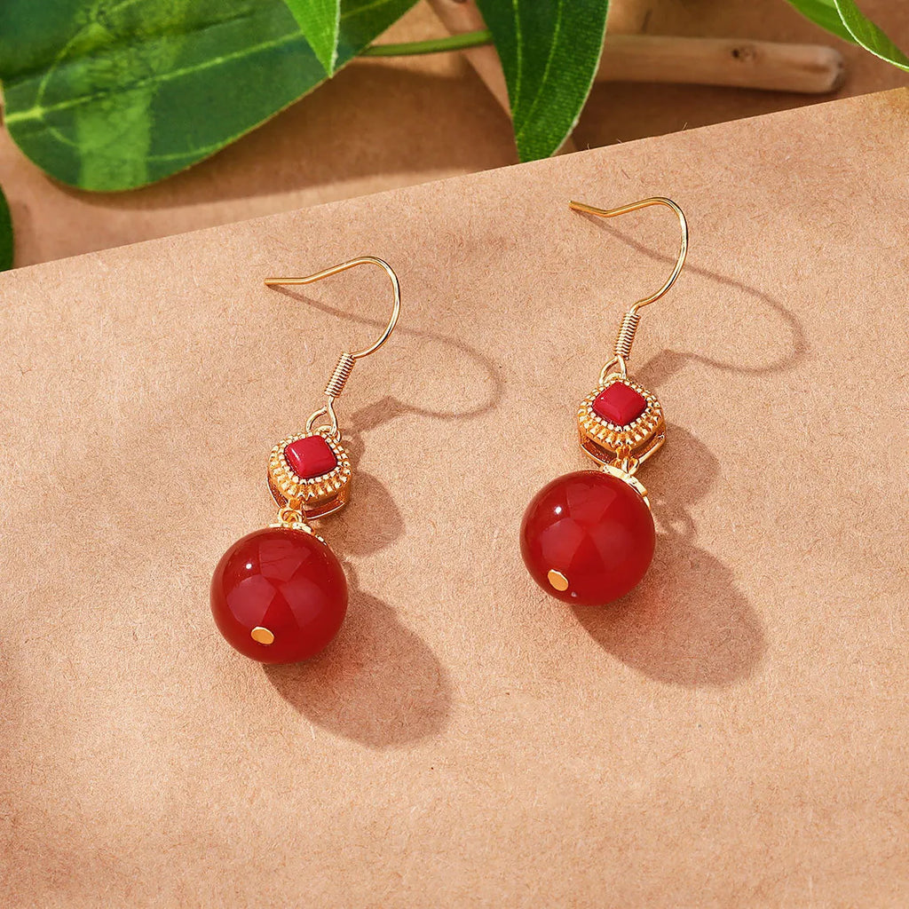 Geometric copper alloy earrings with a round Southern Red Agate bead and S925 sterling silver inlay details.