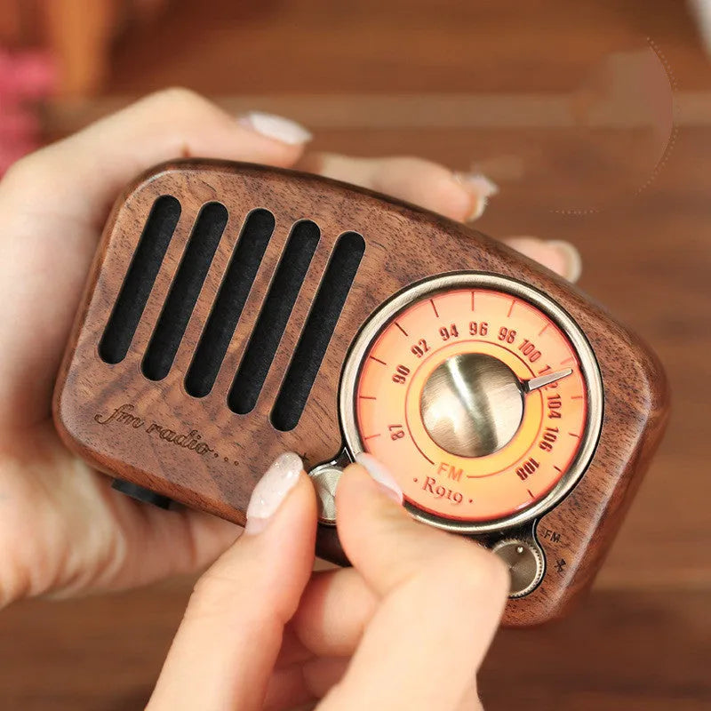 Compact retro wooden Bluetooth mini speaker in cherry wood finish showing front grille and wood grain.
