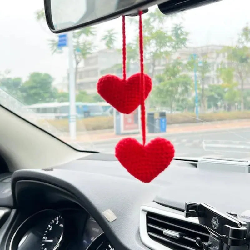 Green and white knitted car plant decoration with hanging rope on car dashboard
