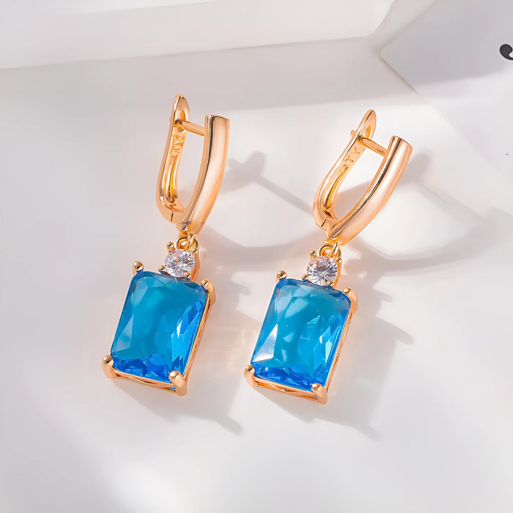 A pair of square geometric earrings with an electroplated gold finish on a copper base.