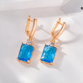 A pair of square geometric earrings with an electroplated gold finish on a copper base.