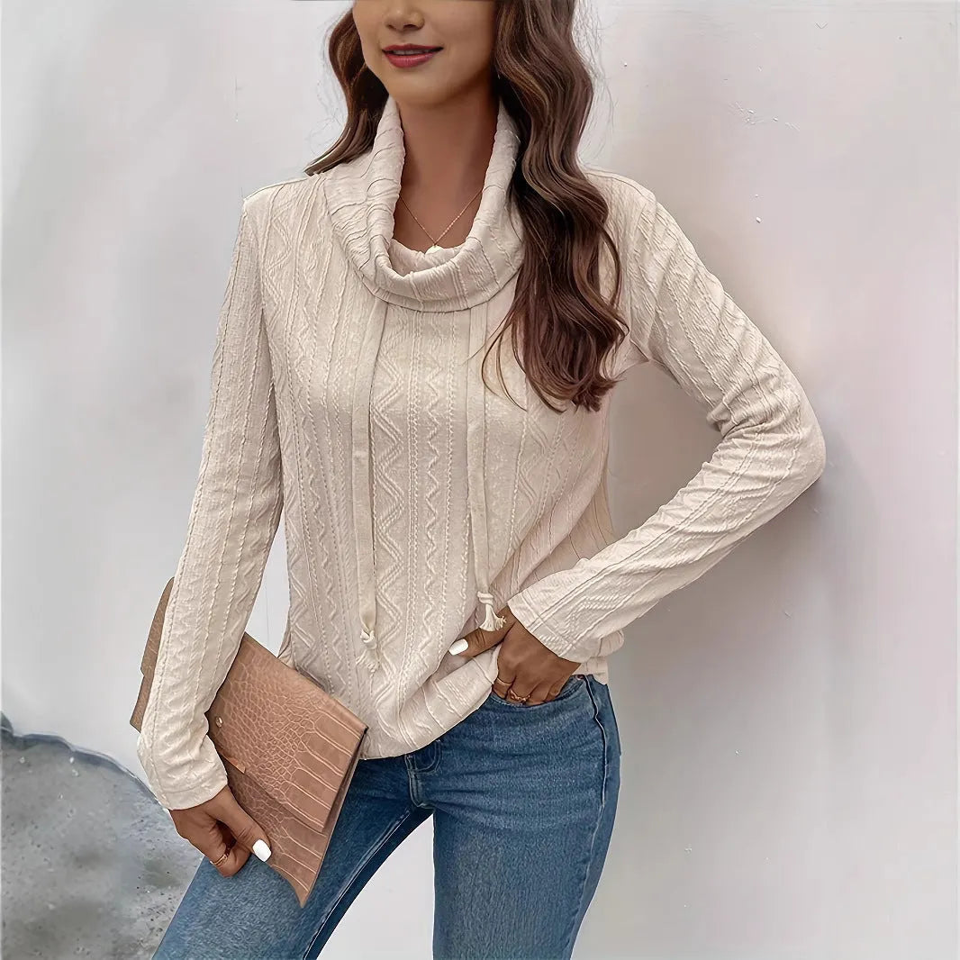 Apricot coloured long sleeve hooded pullover sweater with a drawstring hood on a hanger.