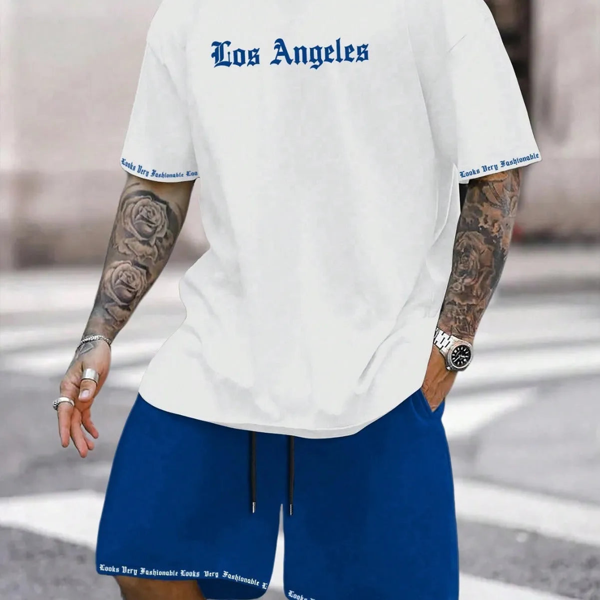 Man wearing a grey short-sleeve top and matching shorts from a sports co-ord set.