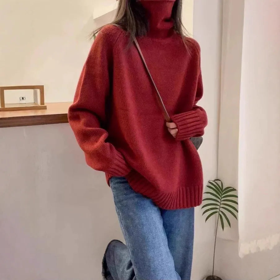 Red women's loose turtleneck sweater with a textured curling pile collar, shown in a casual setting.