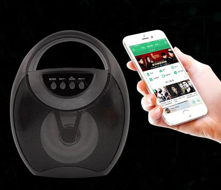 Black portable Bluetooth speaker with USB port and SD card slot on a table.
