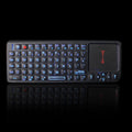 Black wireless mini keyboard with touch screen and matching optical mouse on a desk