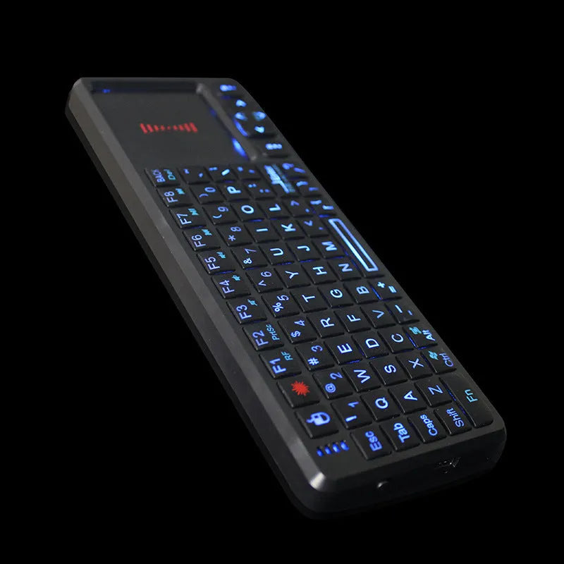 Black wireless mini keyboard with touch screen and matching optical mouse on a desk