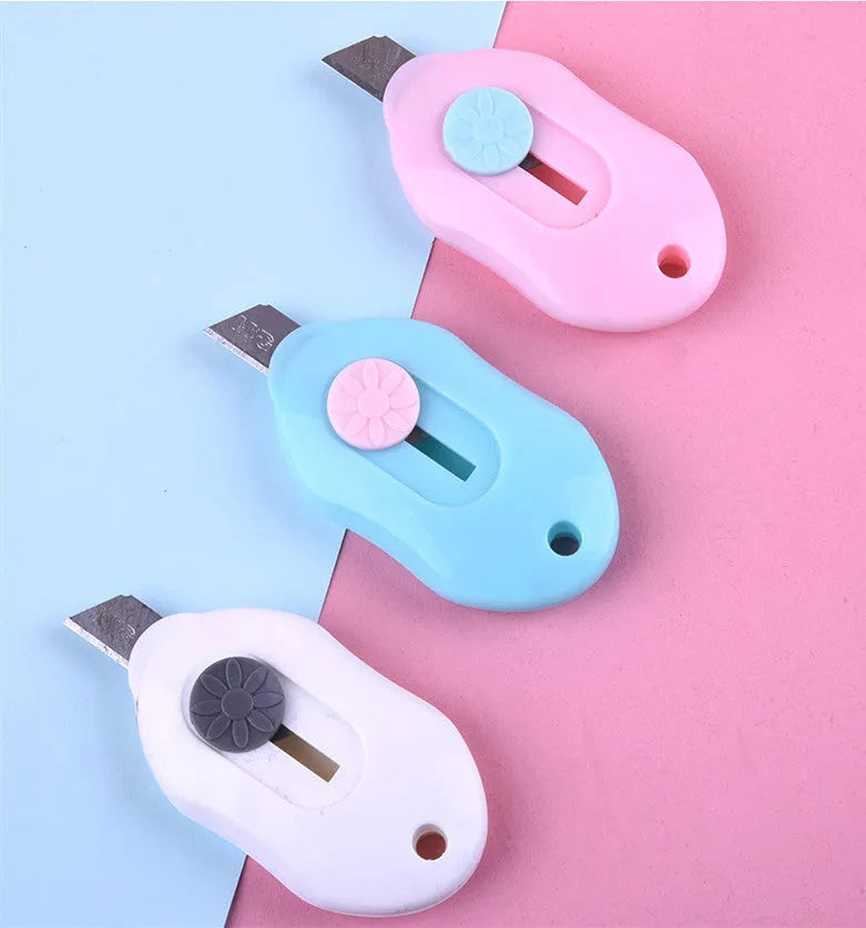 Cartoon art knife with open box mechanism in plastic and metal construction