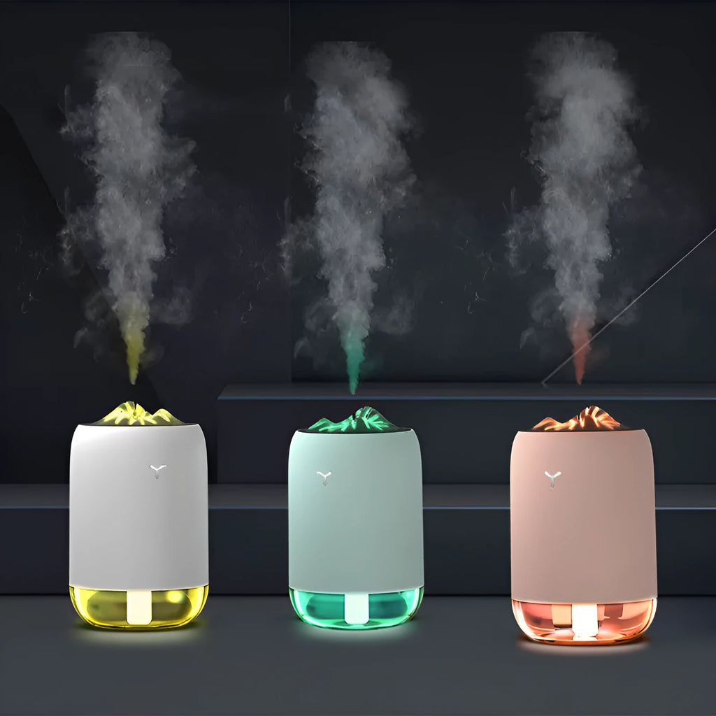 White columnar Magic Flame ultrasonic humidifier with water tank and USB cable on a wooden desk.