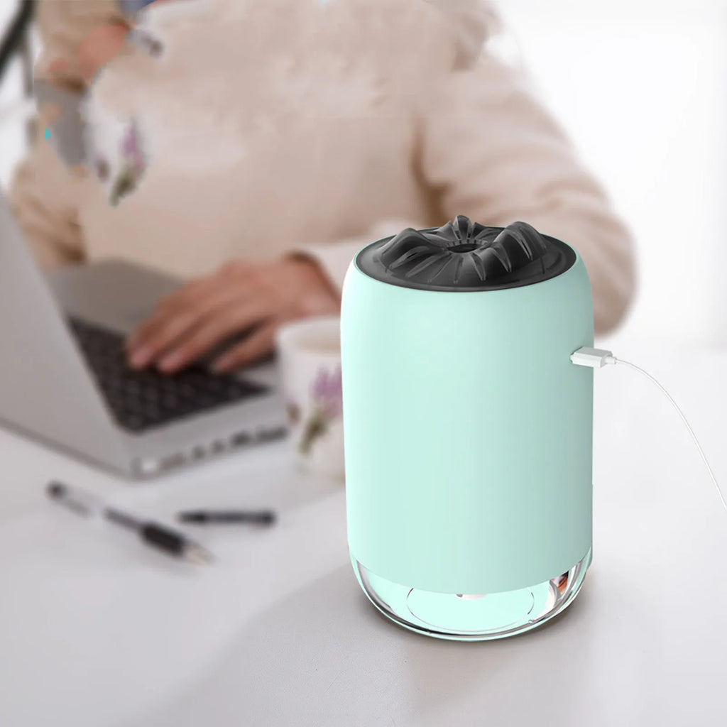 White columnar Magic Flame ultrasonic humidifier with water tank and USB cable on a wooden desk.