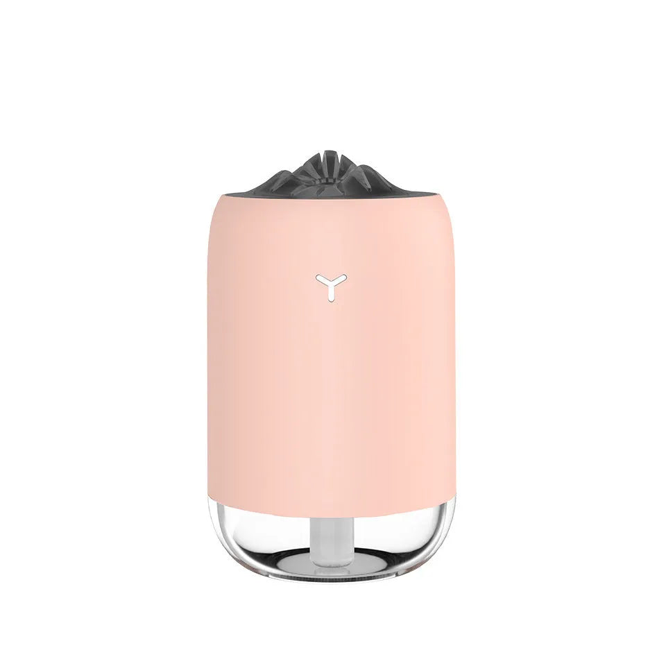 White columnar Magic Flame ultrasonic humidifier with water tank and USB cable on a wooden desk.