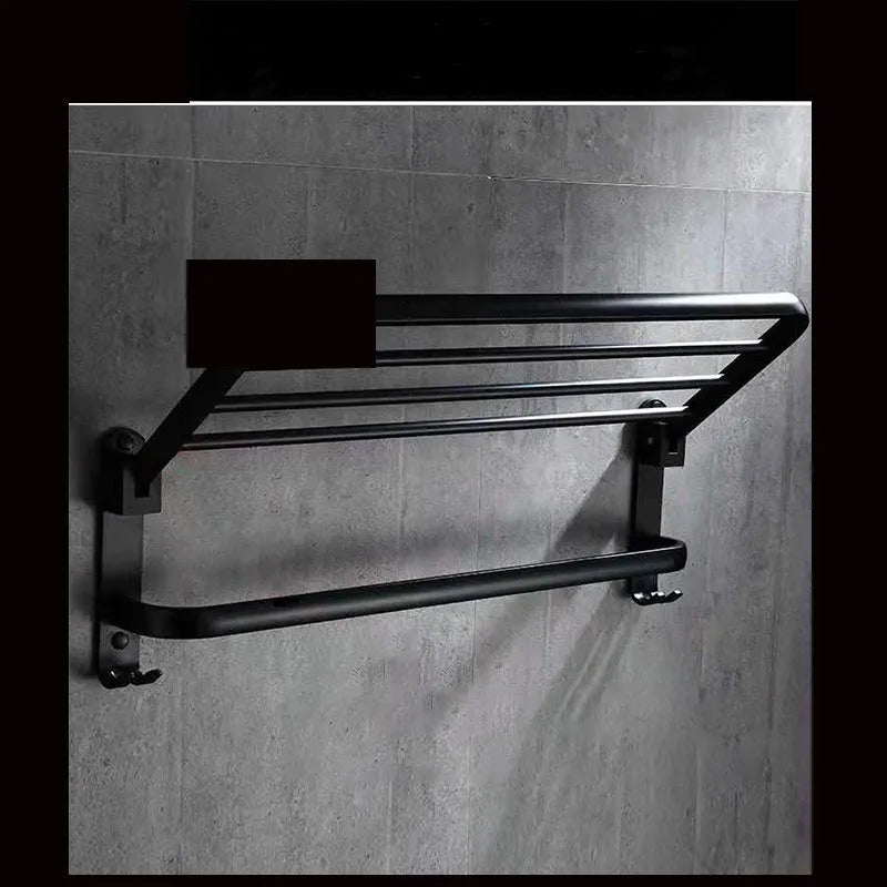 Aluminium two-tier bathroom folding shelf on a white wall, showing optional hooks and perforated surface design.